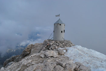 aljažev stolp na Triglavu je ovit v meglo in sneg.
