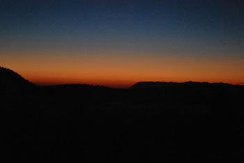 Sončni zahod tik pred nočjo kot se vidi s poti po hribu Koščake.