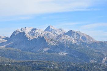 Kser je manj izrazit vrh nad Spodnjo Komno. Na fotografiji se vidijo osrednje Julijske Alpe s Triglavom in gorami, ki ga obdajajo.