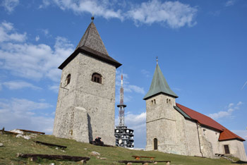 Kum je najvišji dolenjski vrh na katerem stoji stara cerkev svete Neže in zvonik.