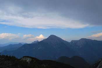 Mali Grintovec je v senci oblakov medtem, ko se odpira razgled na sosednje gore.