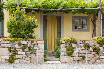 Pepin kraški vrt se ponaša s tipično kraško hišo z zidom in zelenjem.